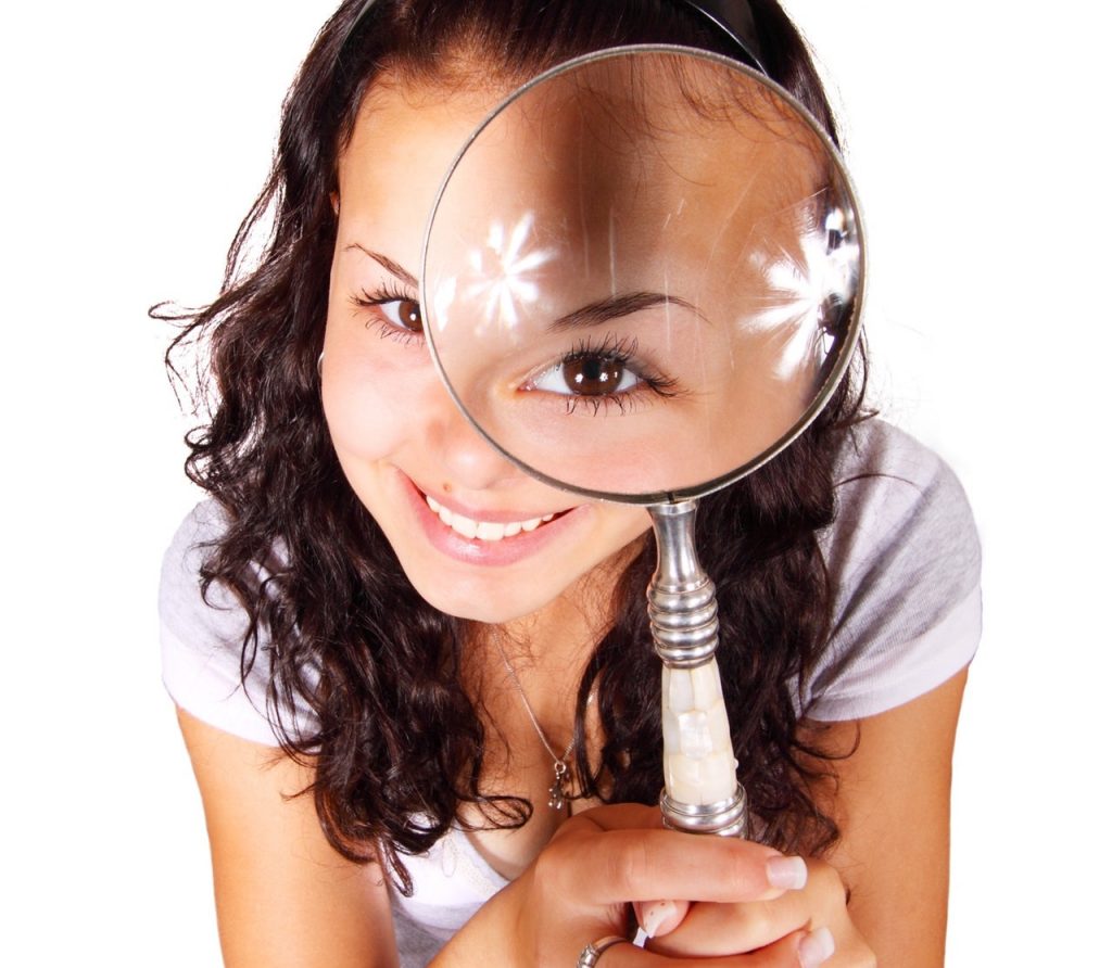 Girl Holding a Magnifier Searching for Quality