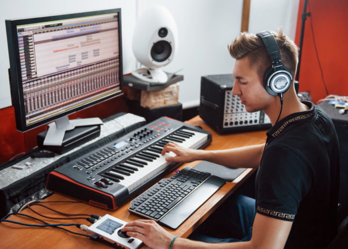 Sound engineer in headphones working and mixing music indoors in the studio